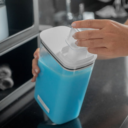 Dispenser Ou com amaciante dentro e sendo colocado o copo medidor na tampa
