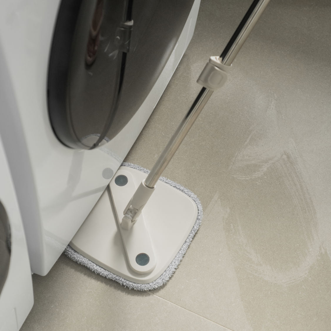Mop Giratório da Ou sendo passado no piso embaixo da máquina de lavar